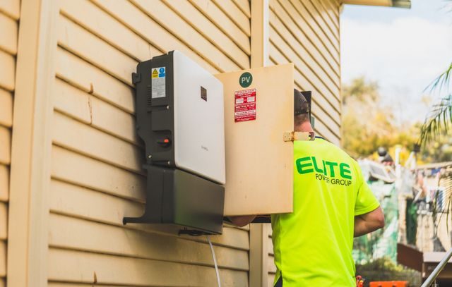 Elektriker installerar en laddbox på en husvägg