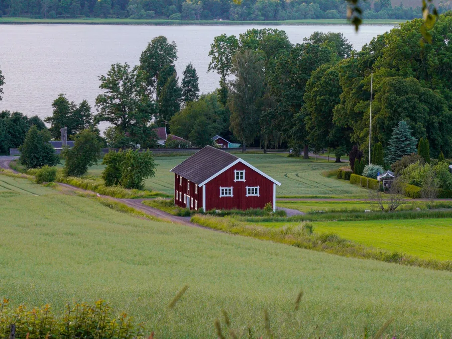 Rött hus vid en sjö på landsbygden