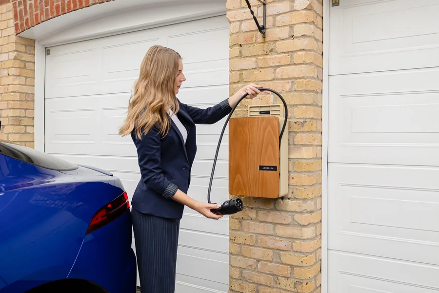Laddbox på en tegelvägg i ett garage där en elbil laddar